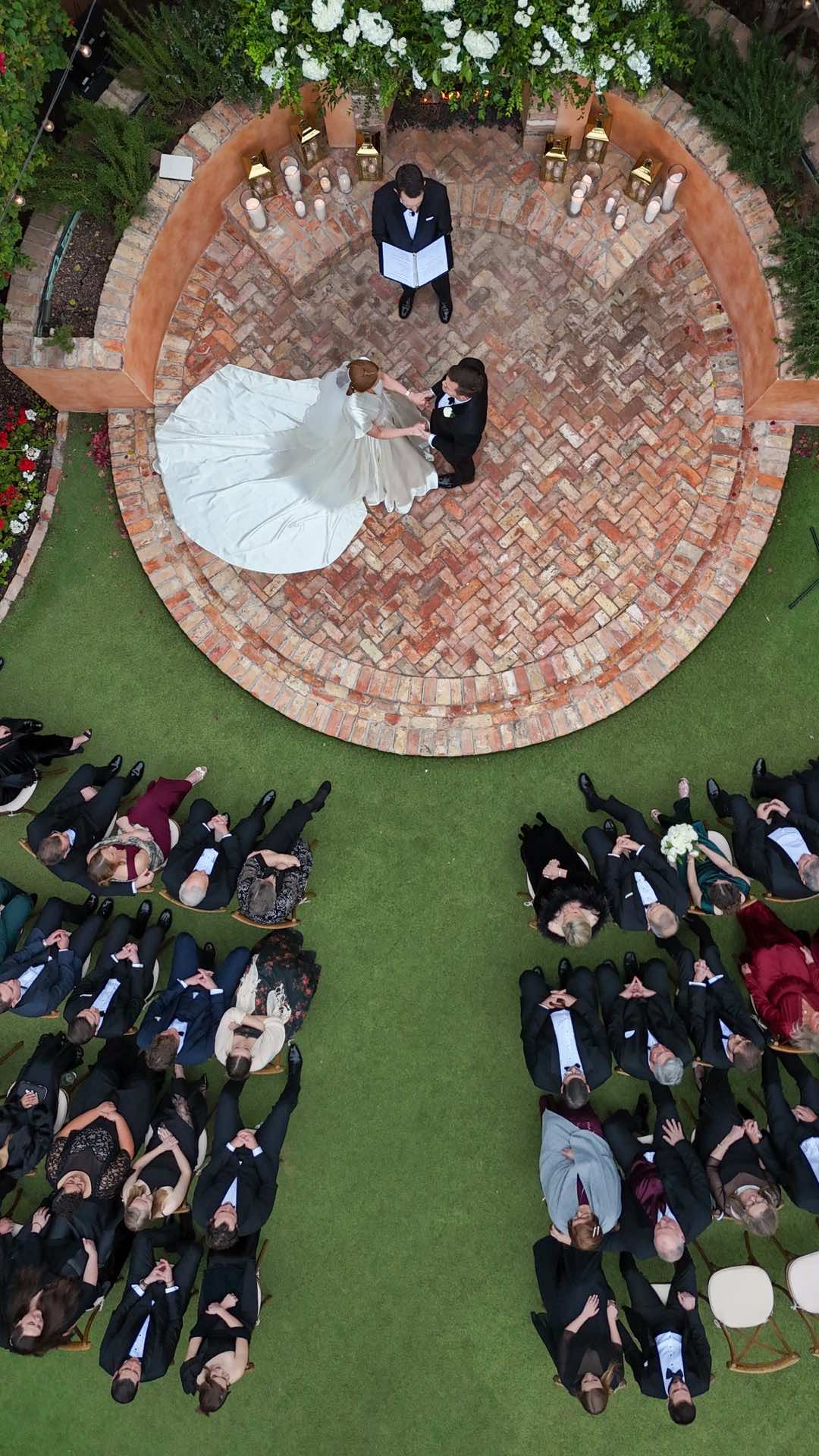 Overhead drone photography of bride and groom at wedding altar with guests